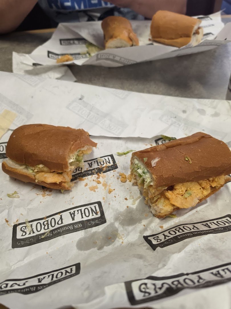 Po'boys and sides on a simple tray.